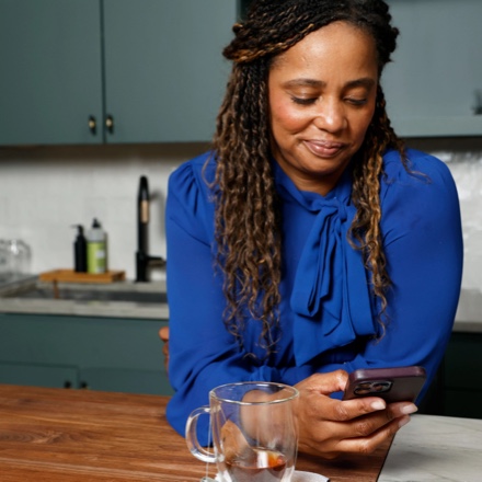 Woman checks her TruStage online account using her mobile device