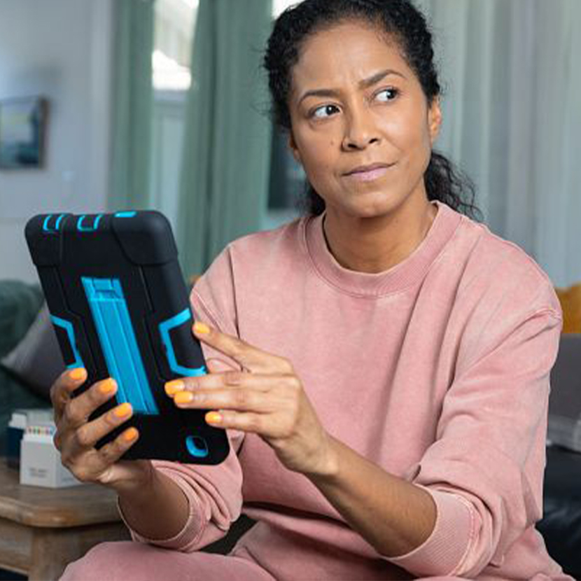 A woman sitting while holding a tablet