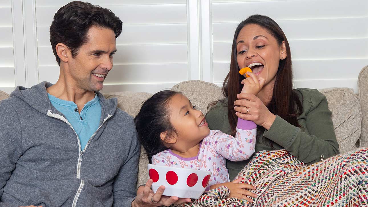 Family sitting on couch, a child playing