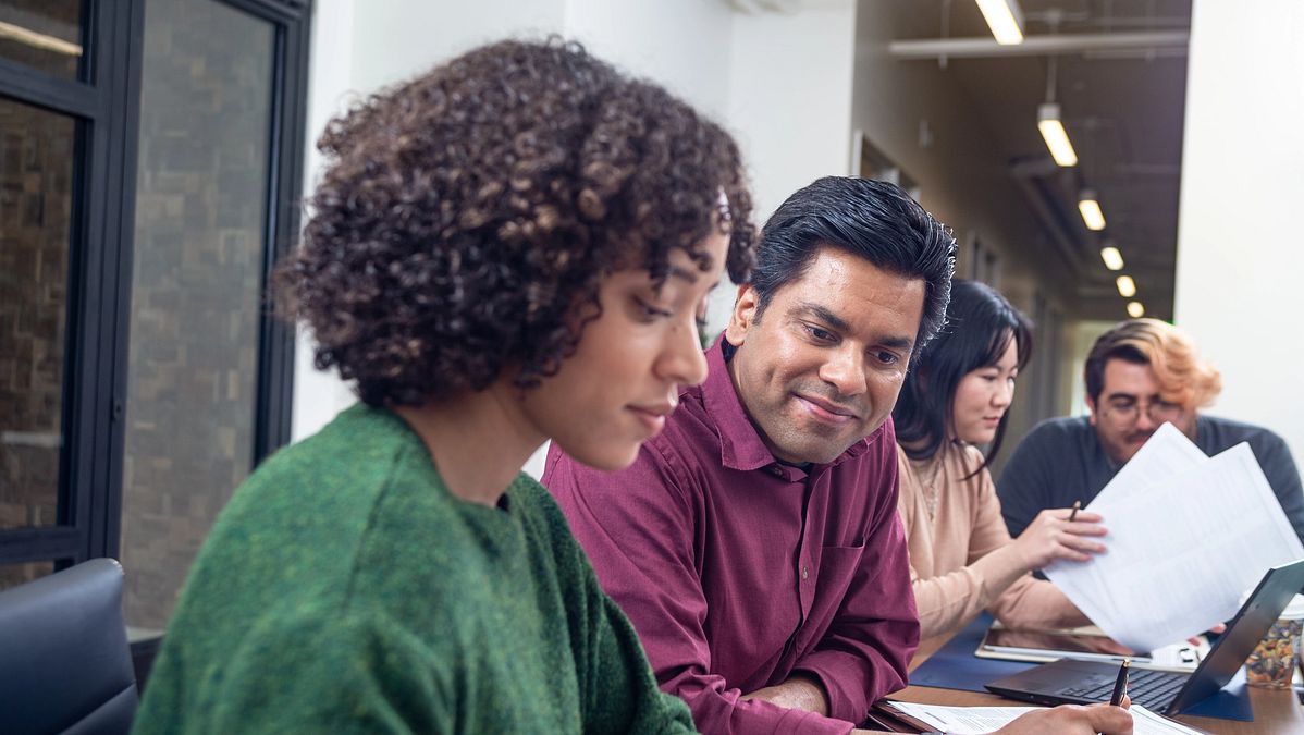 People sit at a table and talk about TruStage workplace solutions