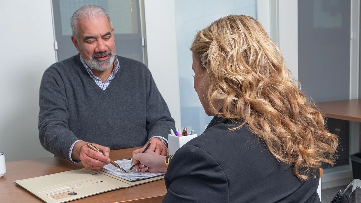 Two people sit and review TruStage workplace solutions