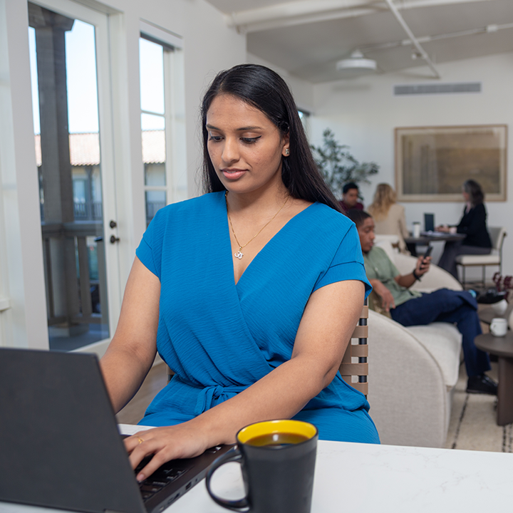 Business woman typing on a laptop in a public space