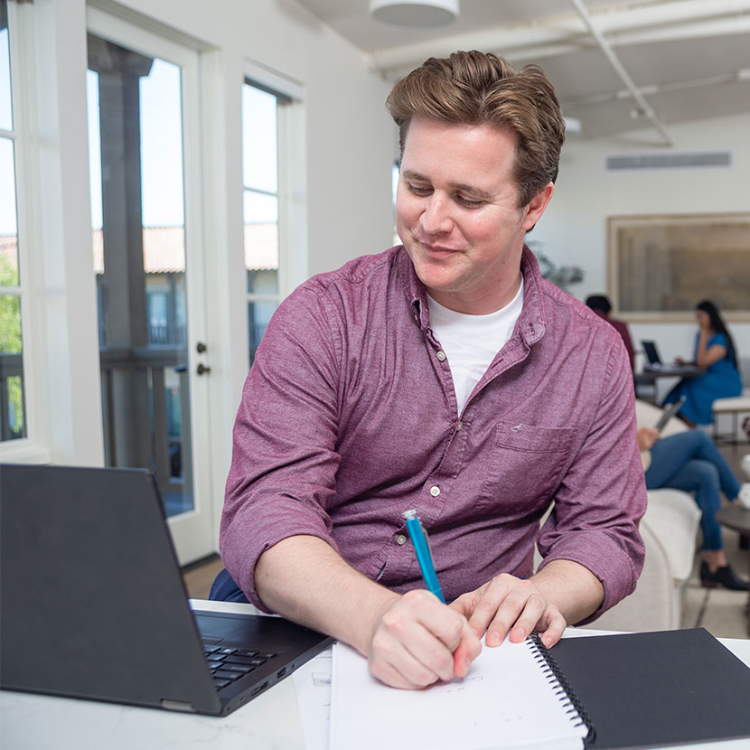 A man taking notes about TruStage Engage Webinars