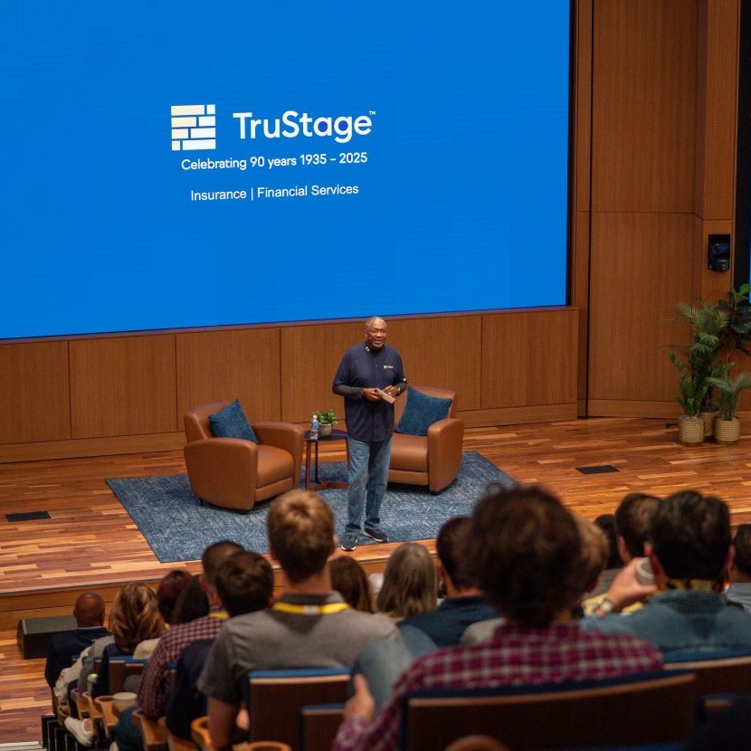 Terrance Williams stands on the auditorium stage to present to TruStage employees.
