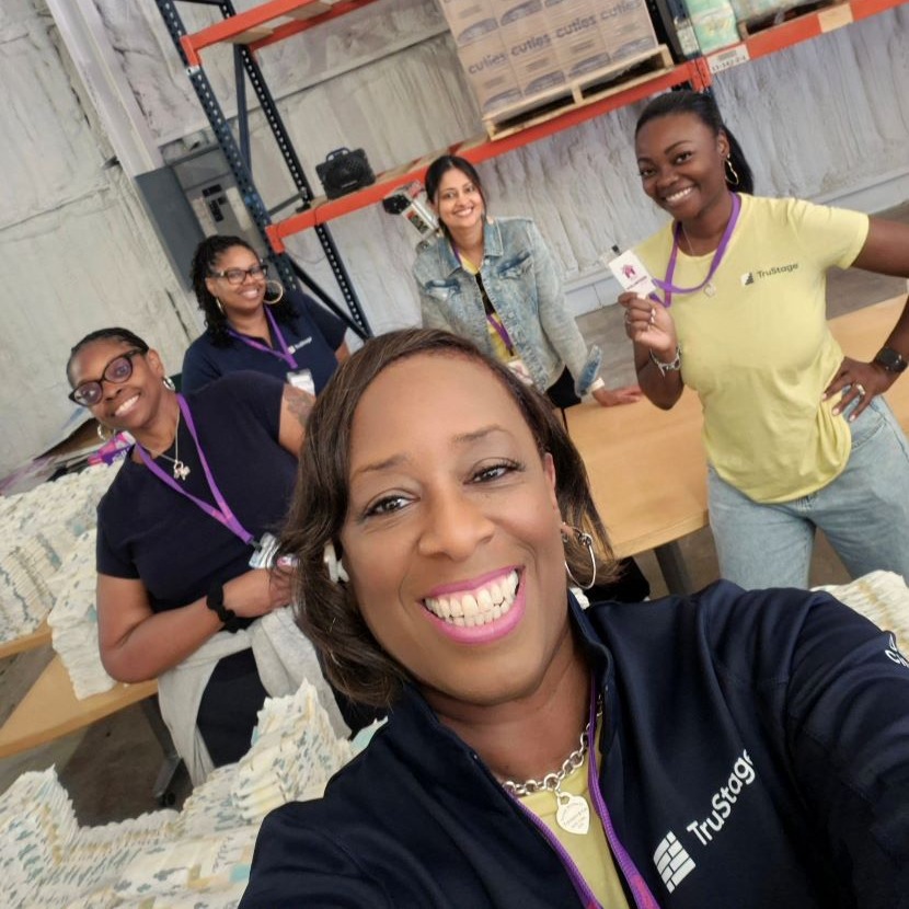 A group of TruStage employees smile as they volunteer in their local community.