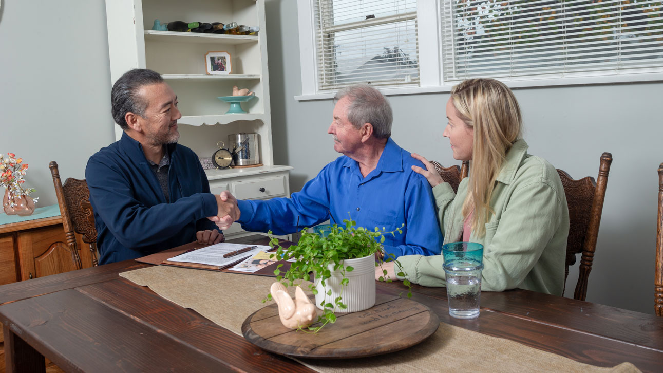 Three people sitting around a table discussing TruStage values