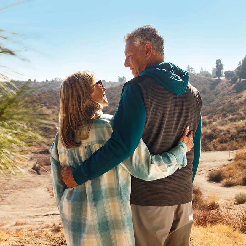 A woman and a man pause their nature hike to reflect on their finacial future that includes an annuity from TruStage.