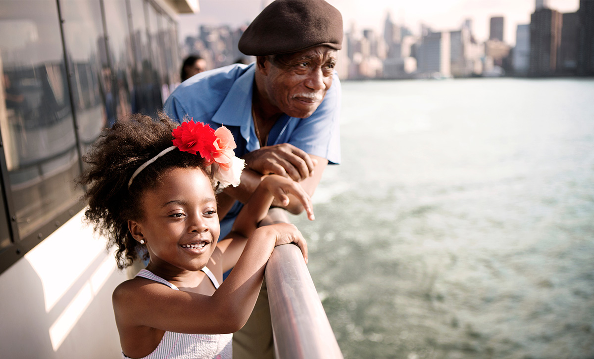 An man and his granddaughter riding a ferry; he's secure about his financial future that includes a TruStage annuity.