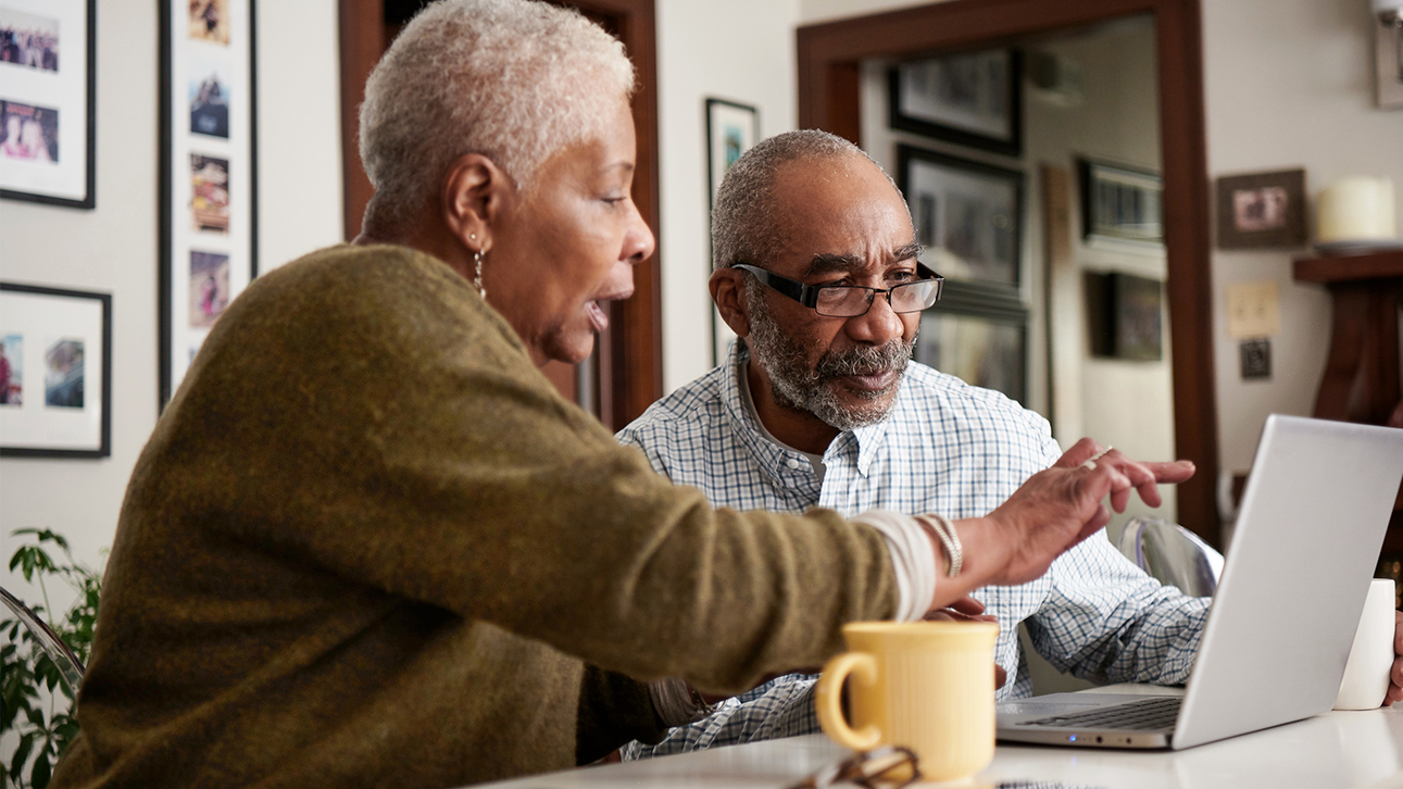 Two people looking at the peformance of their annuities on a laptop computer