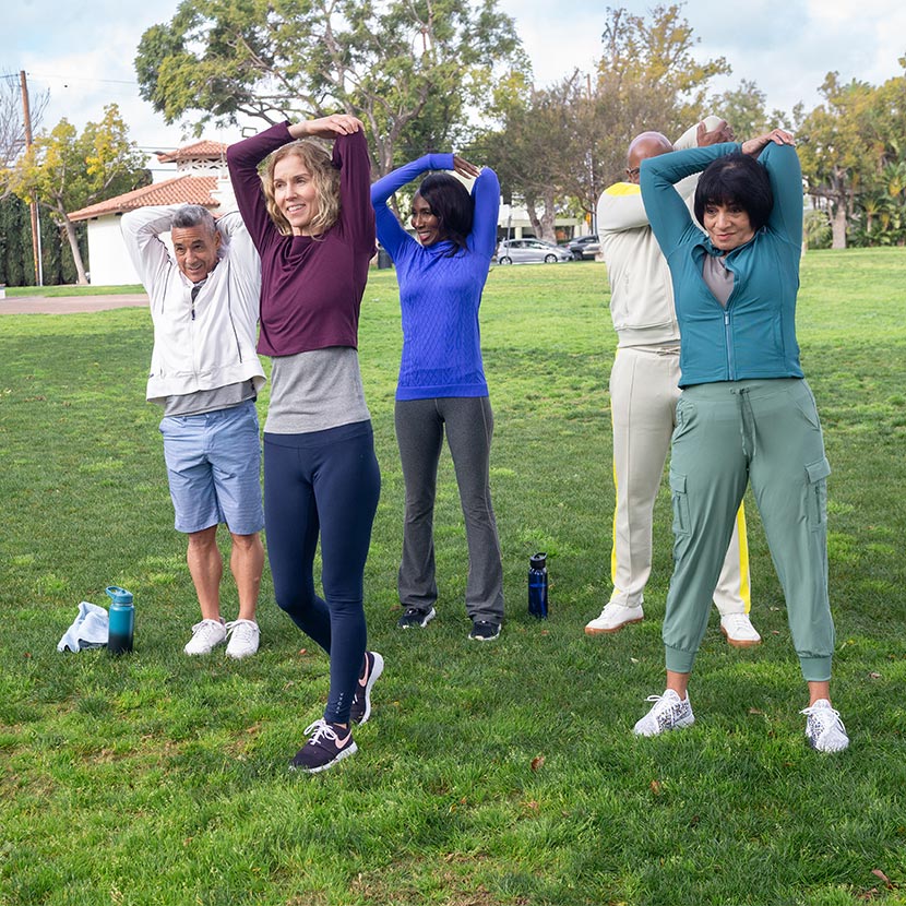 A woman stretching outdoors with a few others is not worried about her retirement, thanks to Max Protect Fixed Annuity 