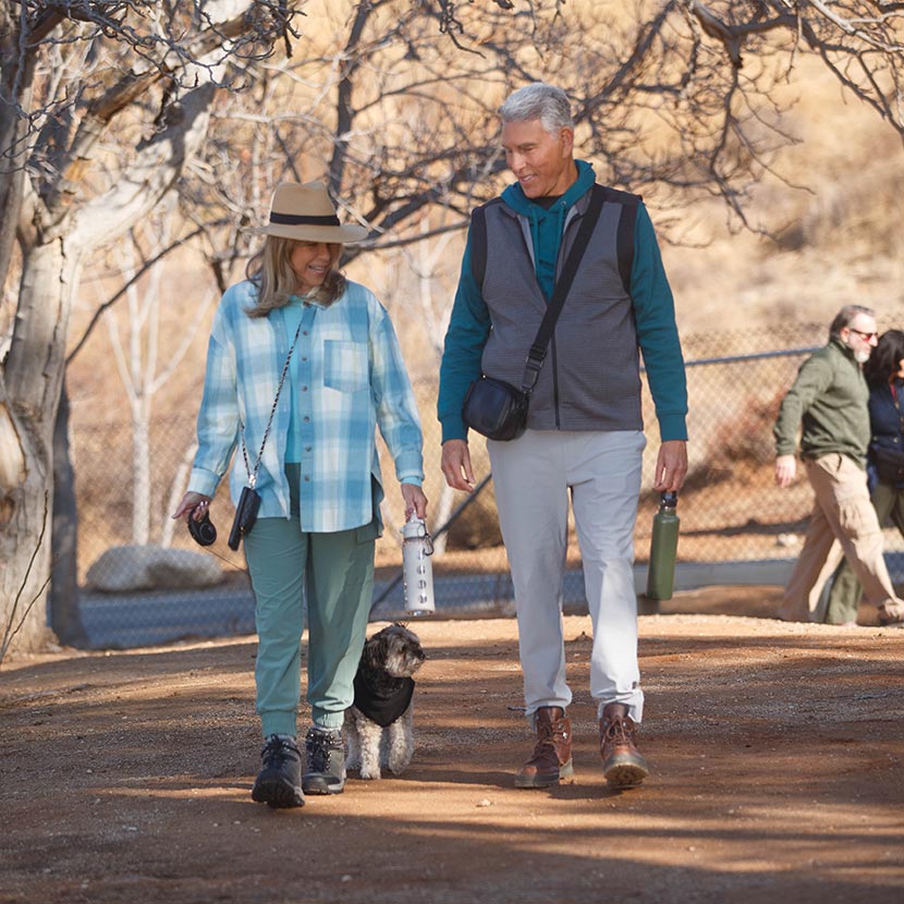 A man and woman walking in the park discussing the performance of their Single Premium Immediate Annuity from TruStage