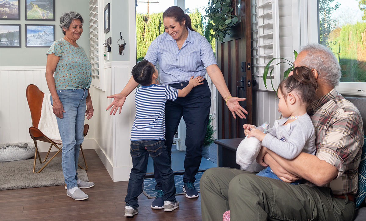 A child and mom hug in front of grandparents that are secure in retirement thanks to ZoneChoice Income Annuity from TruStage™.