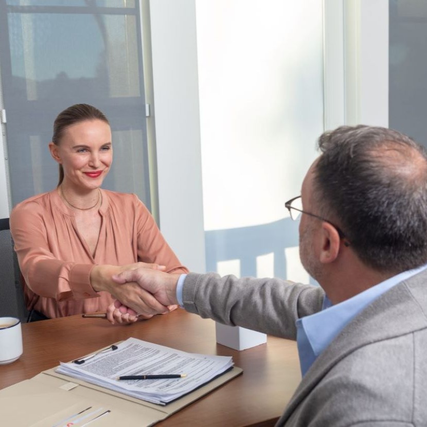 Man and woman shaking hands in agreement over TruStage life insurance policy.
