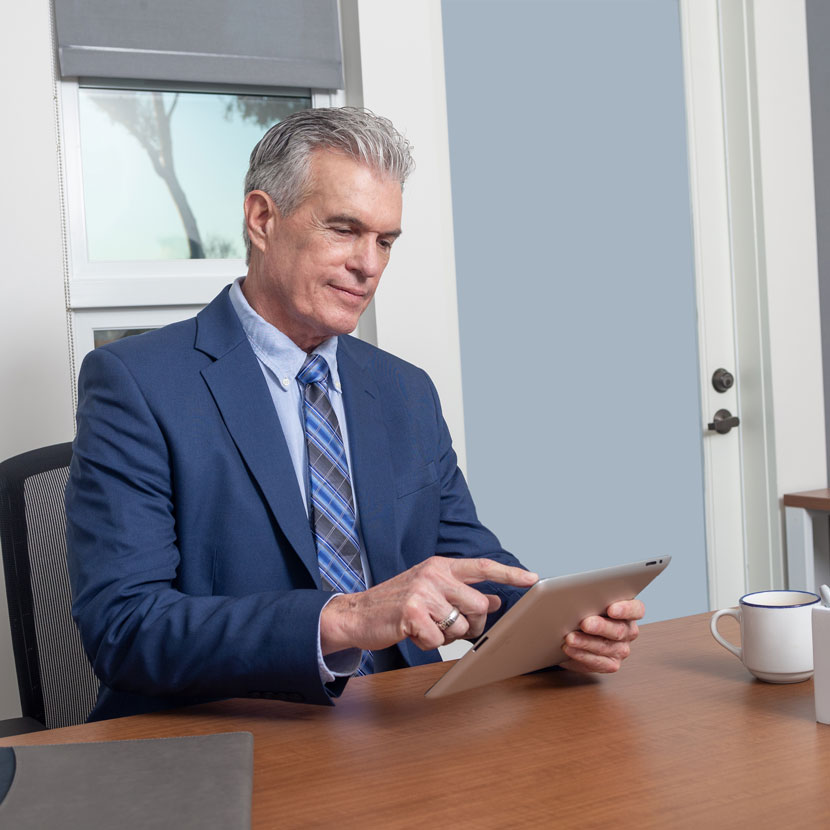 A man reviews TruStage's webinar schedule on a tablet