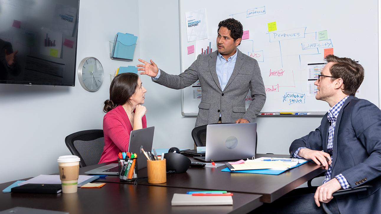 Group of people in an office discussing TruStage speaker resources.