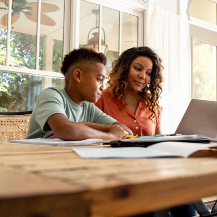 Mom helping son with homework, protected by TruStage Life Insurance. 