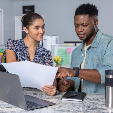 A couple looking at loan papers at the kitchen table.