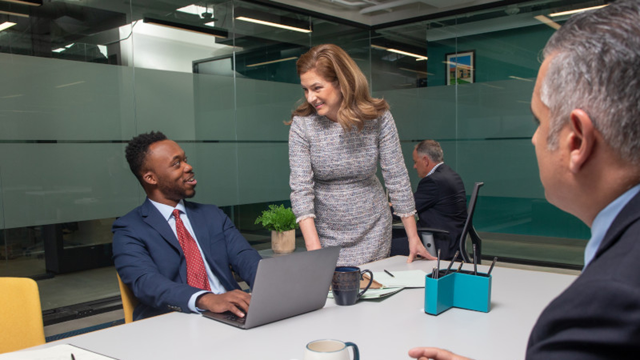 Conference room discussion between employees.