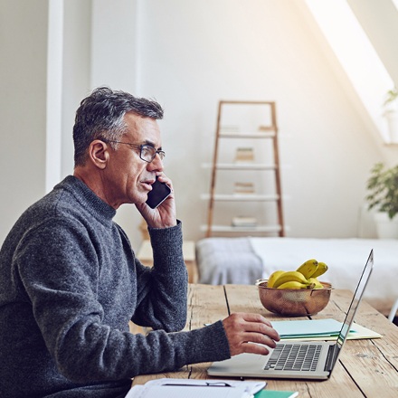 Man sitting at computer learning about insurance riders