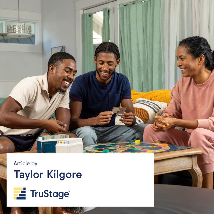 A Black family playing a game at a table and having fun