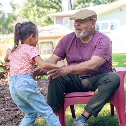 Grandfather playing with granddaughter outside