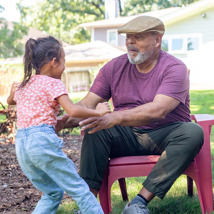 Grandfather playing with granddaughter outside