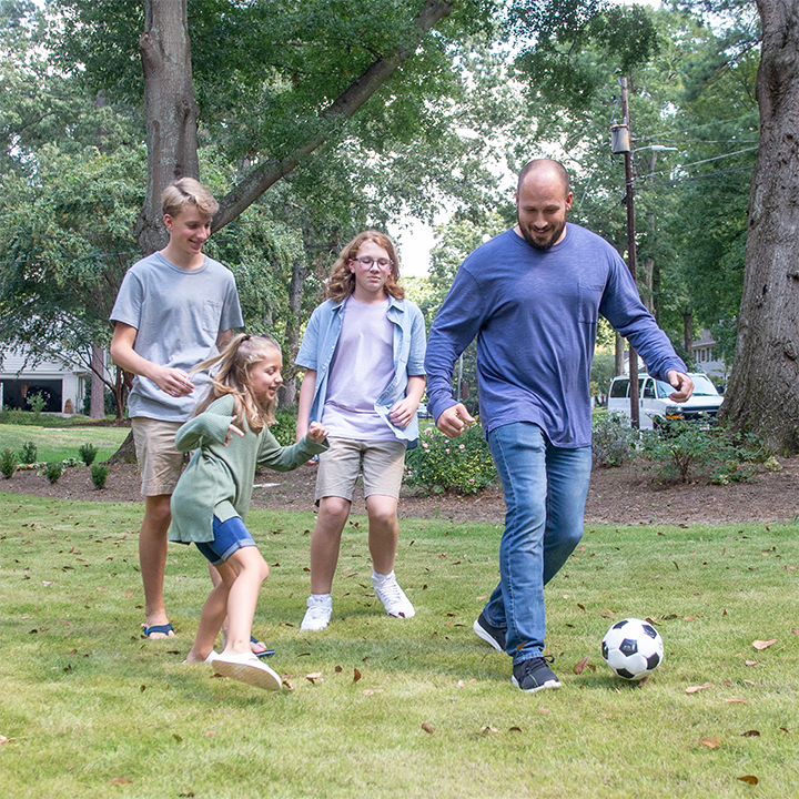 Father playing soccer with his children