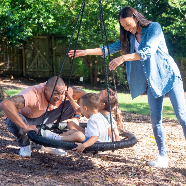 Happy family on a playground protected by life insurance