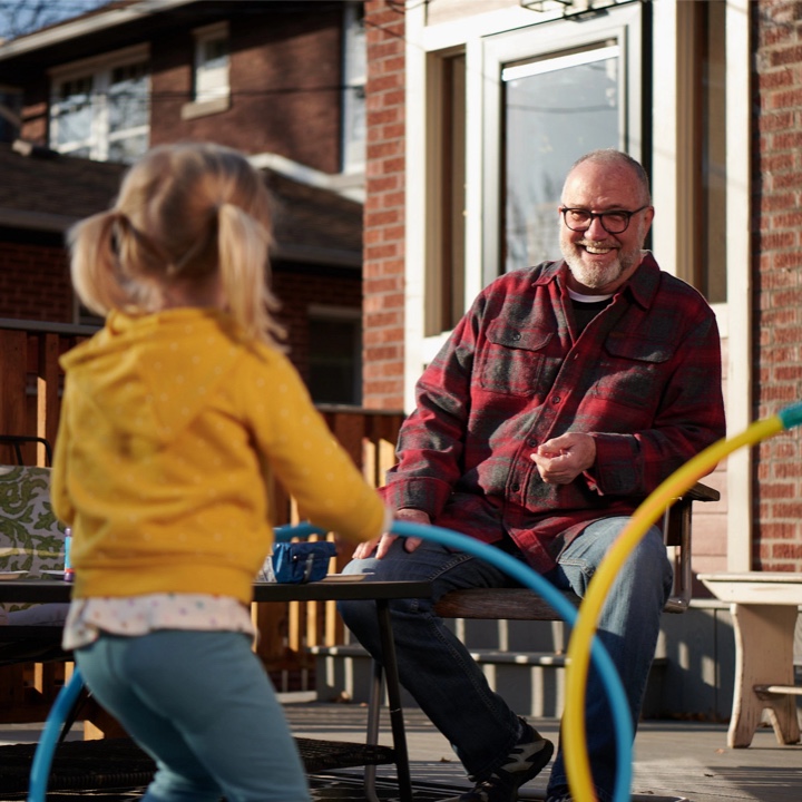 Grandparent protected by a whole life policy with his grandchild playing outdoors