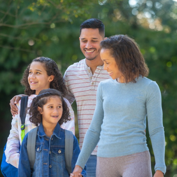 A family covered by life insurance walks together outdoors