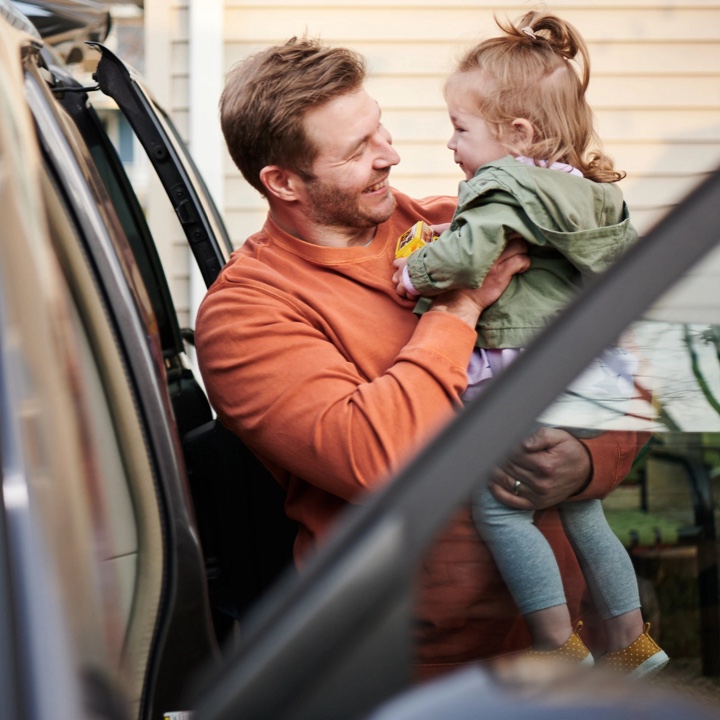 Dad ready to load his daughter into their SUV equipped with an auto tracking device