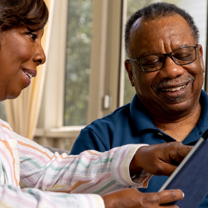 A couple views their insurance policy on a tablet and discusses it