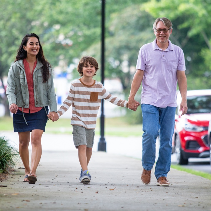 Parents at peace, thanks to their insurance coverage, on a walk with their son