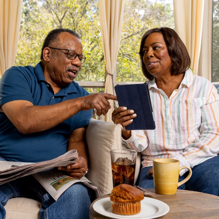 A couple uses their tablet to review their insurance coverage