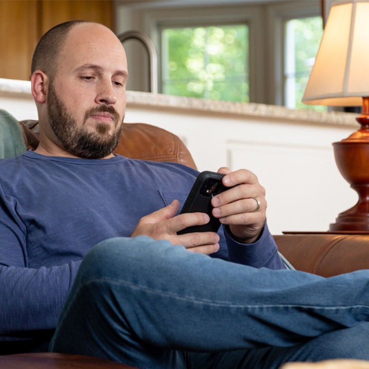 Man learning about life insurance scams on his phone