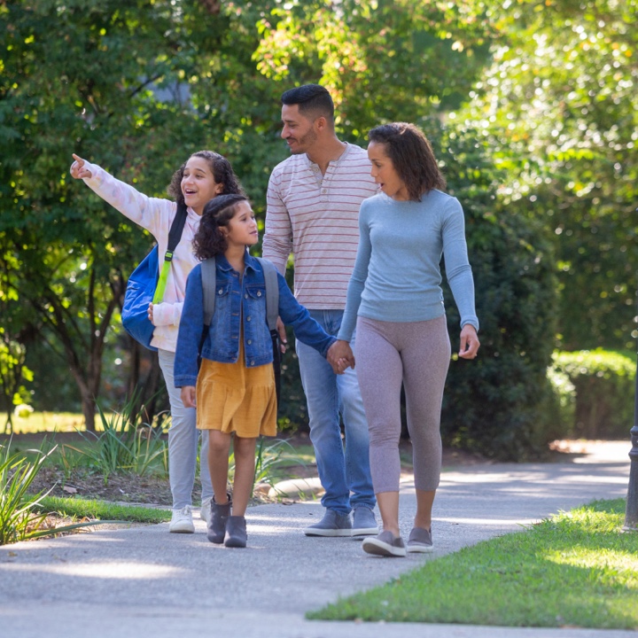 A family walks down the sidewalk secure in the insurance coverage