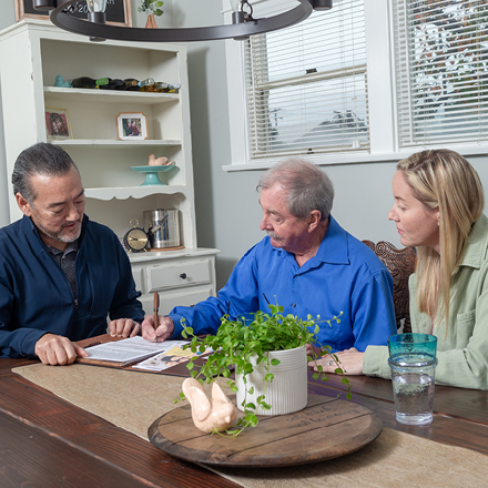 A man and his daughter meet with an advisor to talk about permanent life insurance