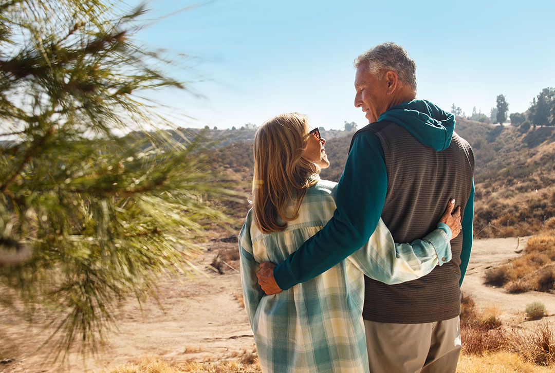 A man and woman embrace one another, feeling relieved they have flexibility for retirement planning with TruStage.