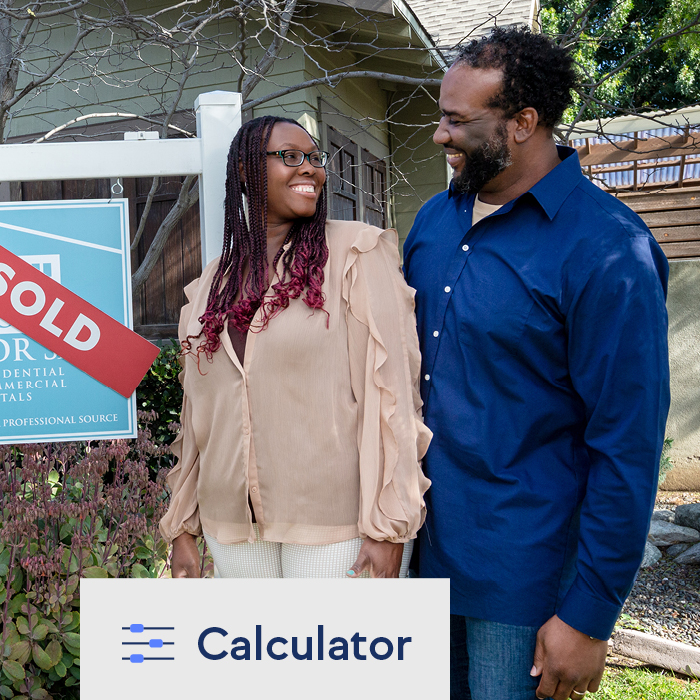 A happy couple standing in front of their new house