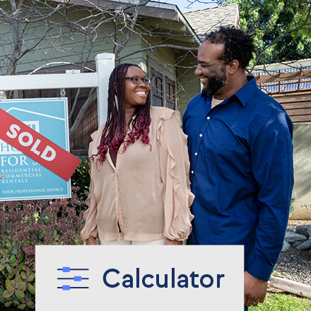 A happy couple standing in front of their new house