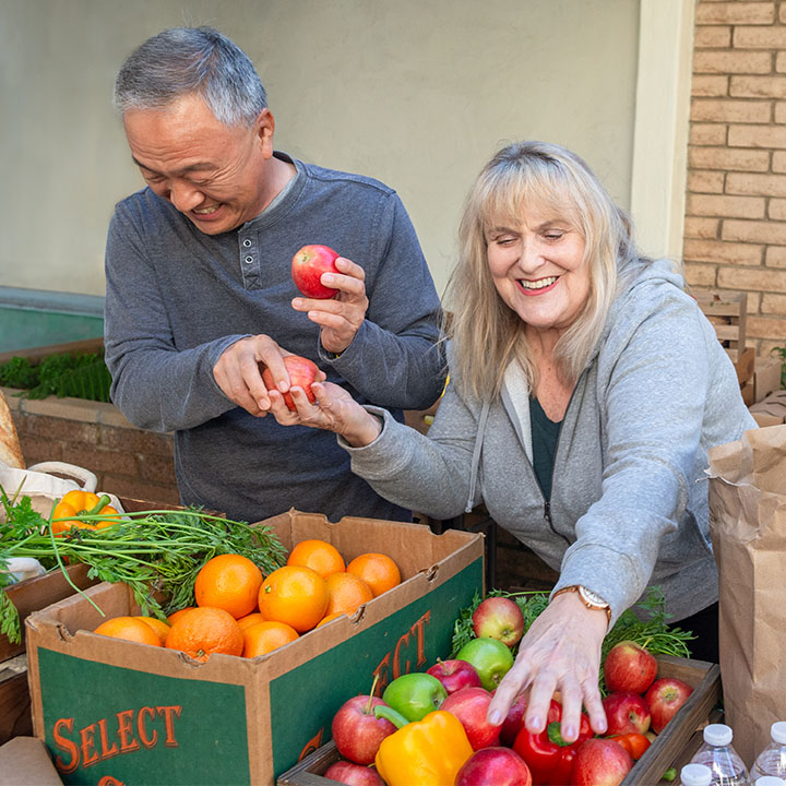 Two retirees at a farmers market are better protected in their retirement with an annuity from TruStage.