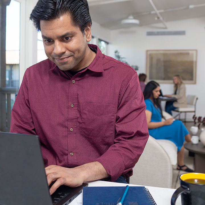A man uses a laptop to look up information about his TruStage policy and then makes some policy updates.
