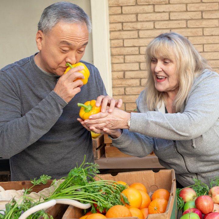 A man and woman inspect fresh produce.