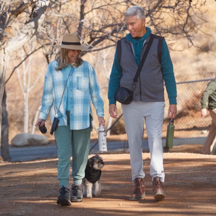 A couple in their 60s walking their dog