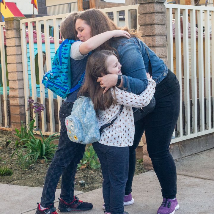 A mom hugs her two kids and is better protected by TruStage Life Insurance.