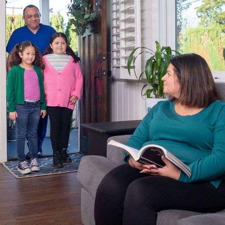 Two grandkids and grandpa greet grandma in her home protected by TruStage Insurance.