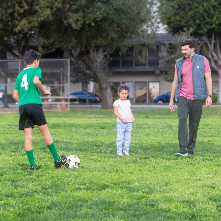 A dad playing soccer with his kids has piece of mind thanks to his TruStage Life Insurance policy.