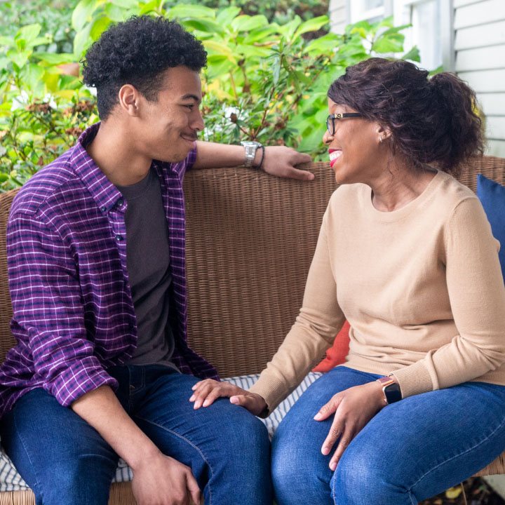 A younger couple on a couch discuss their TruStage Life Insurance policy.
