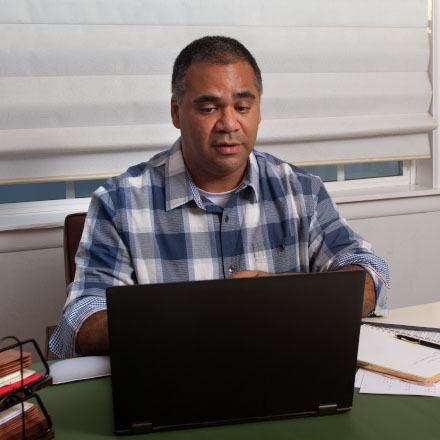 A man reviews his TruStage Insurance application using his laptop.