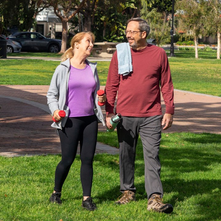 A husband and wife just finished their outdoor workout and discuss their TruStage Insurance policy